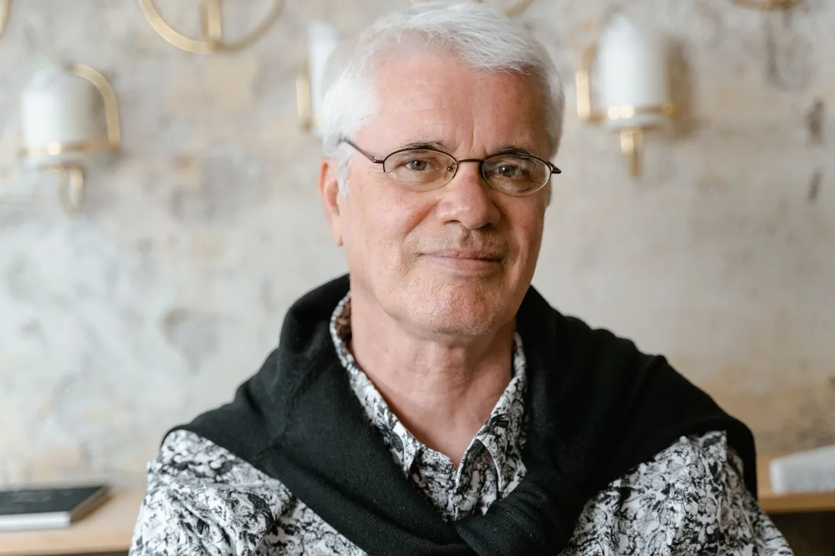 A man wearing glasses, smiling